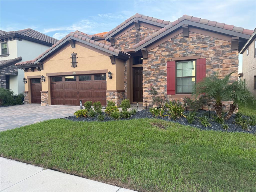 10958 Rustic Timber Loop San Antonio, FL 33576 - Photo 1 of 48 a front view of a house with a yard and garage