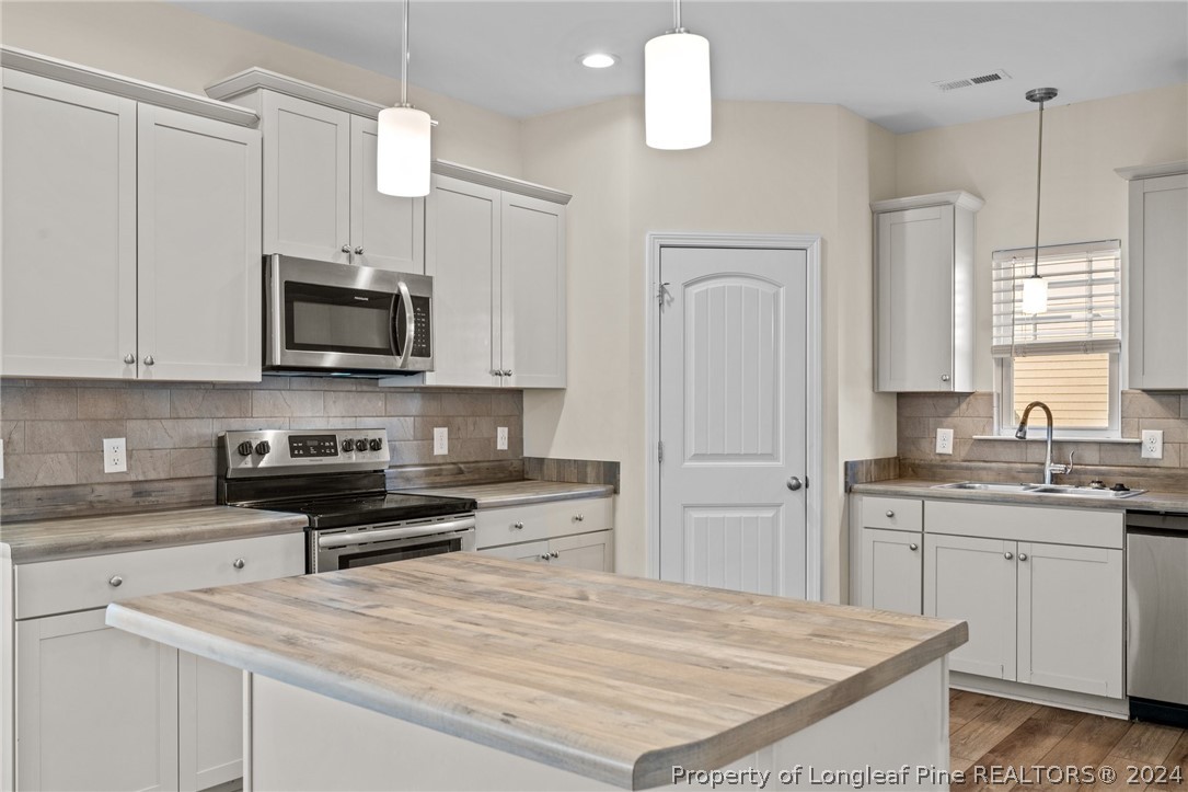 560 Angel Oak Drive Bunnlevel, NC 28323 - Photo 19 of 49 a kitchen with stainless steel appliances granite countertop a sink a stove and a microwave