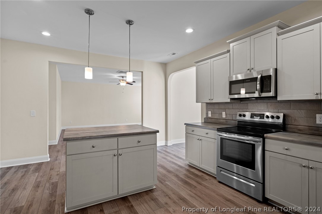 560 Angel Oak Drive Bunnlevel, NC 28323 - Photo 21 of 49 a kitchen with white cabinets and stainless steel appliances