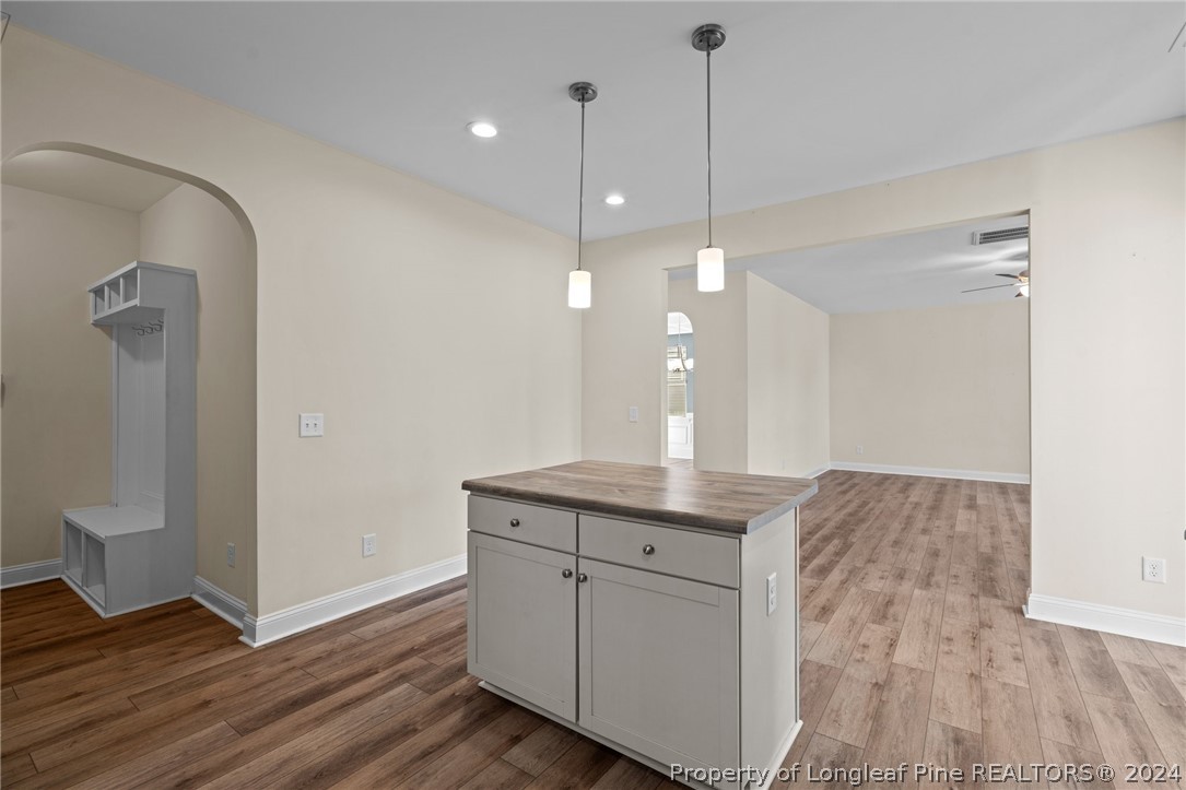 560 Angel Oak Drive Bunnlevel, NC 28323 - Photo 23 of 49 a kitchen with kitchen island white cabinets and wooden floor