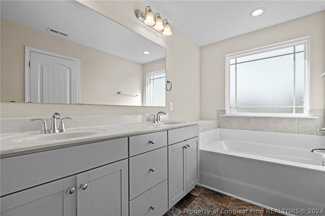 560 Angel Oak Drive Bunnlevel, NC 28323 - Photo 32 of 49 a bathroom with a tub a sink and mirror