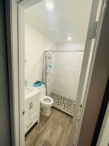 a bathroom with a sink a toilet and shower