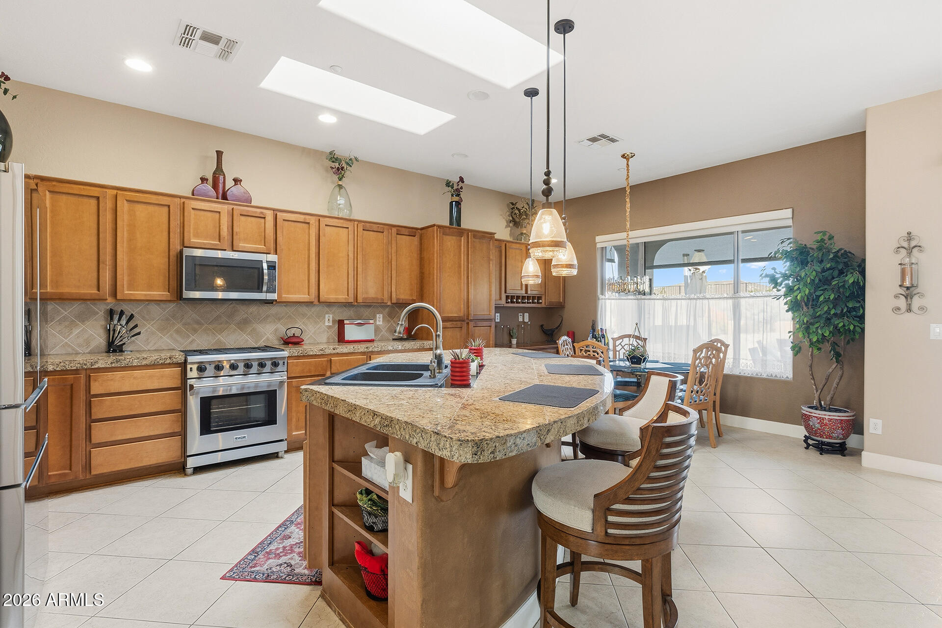 41712 North Golf Crest Road Anthem, AZ 85086 - Photo 16 of 39 a kitchen with a stove a sink a oven a dining table and chairs