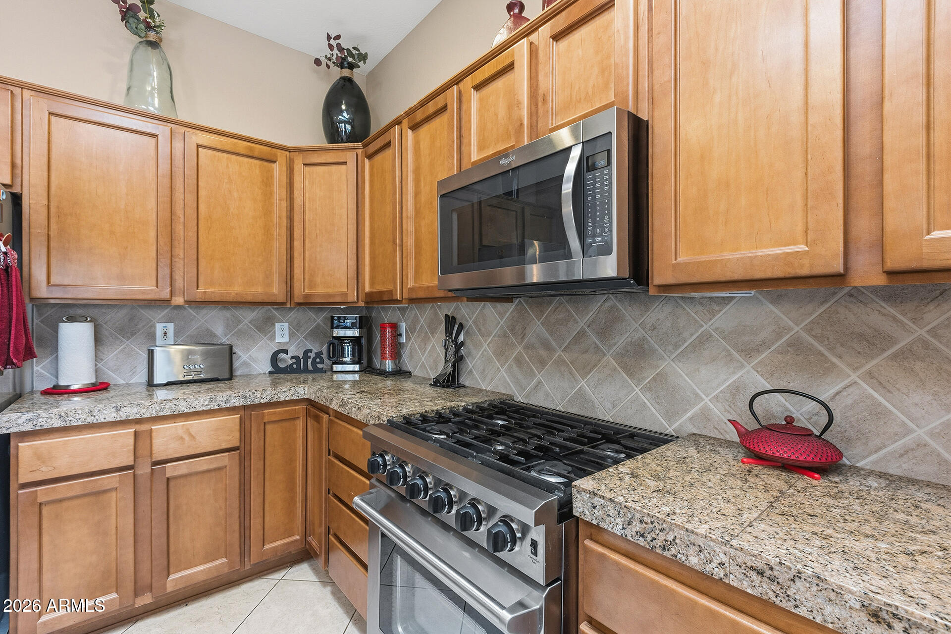 41712 North Golf Crest Road Anthem, AZ 85086 - Photo 21 of 39 a kitchen with stainless steel appliances granite countertop a stove a sink and a microwave