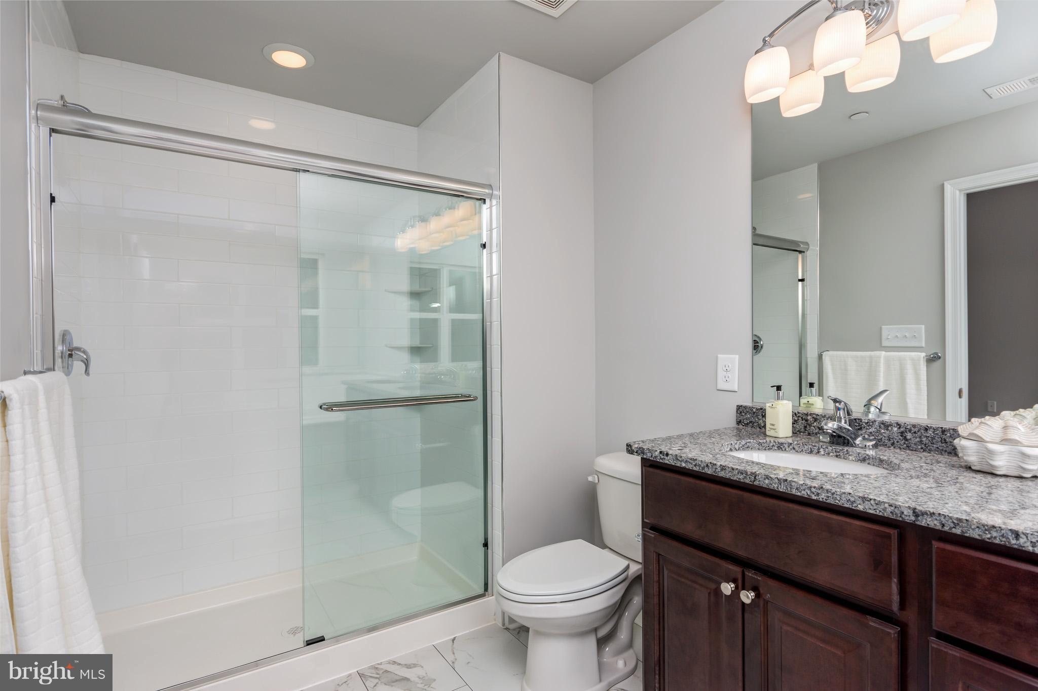 8035 Clark Station Road Severn, MD 21144 - Photo 16 of 24 a bathroom with a granite countertop sink toilet and shower