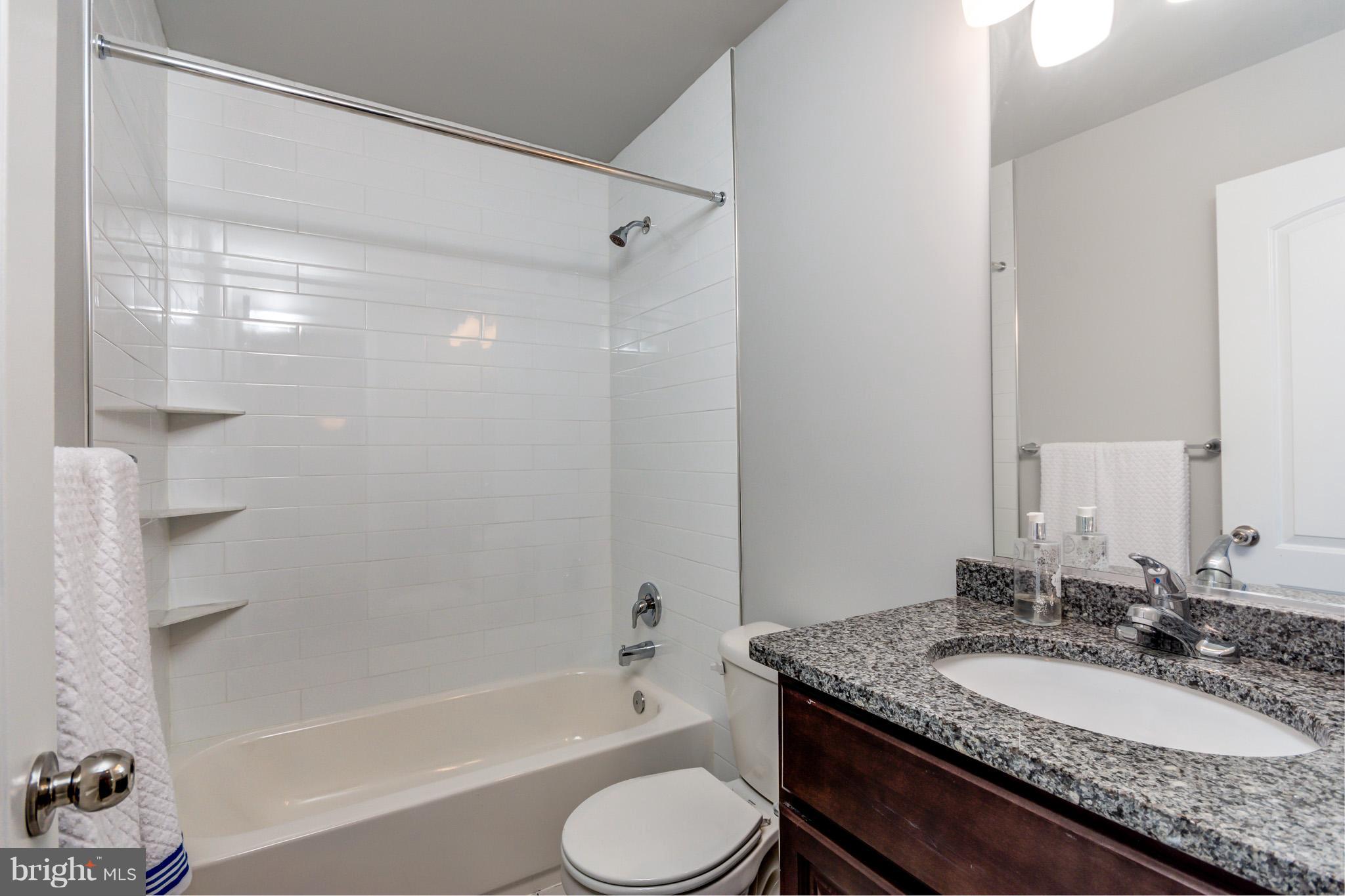 8035 Clark Station Road Severn, MD 21144 - Photo 19 of 24 a bathroom with a granite countertop sink toilet bathtub and shower