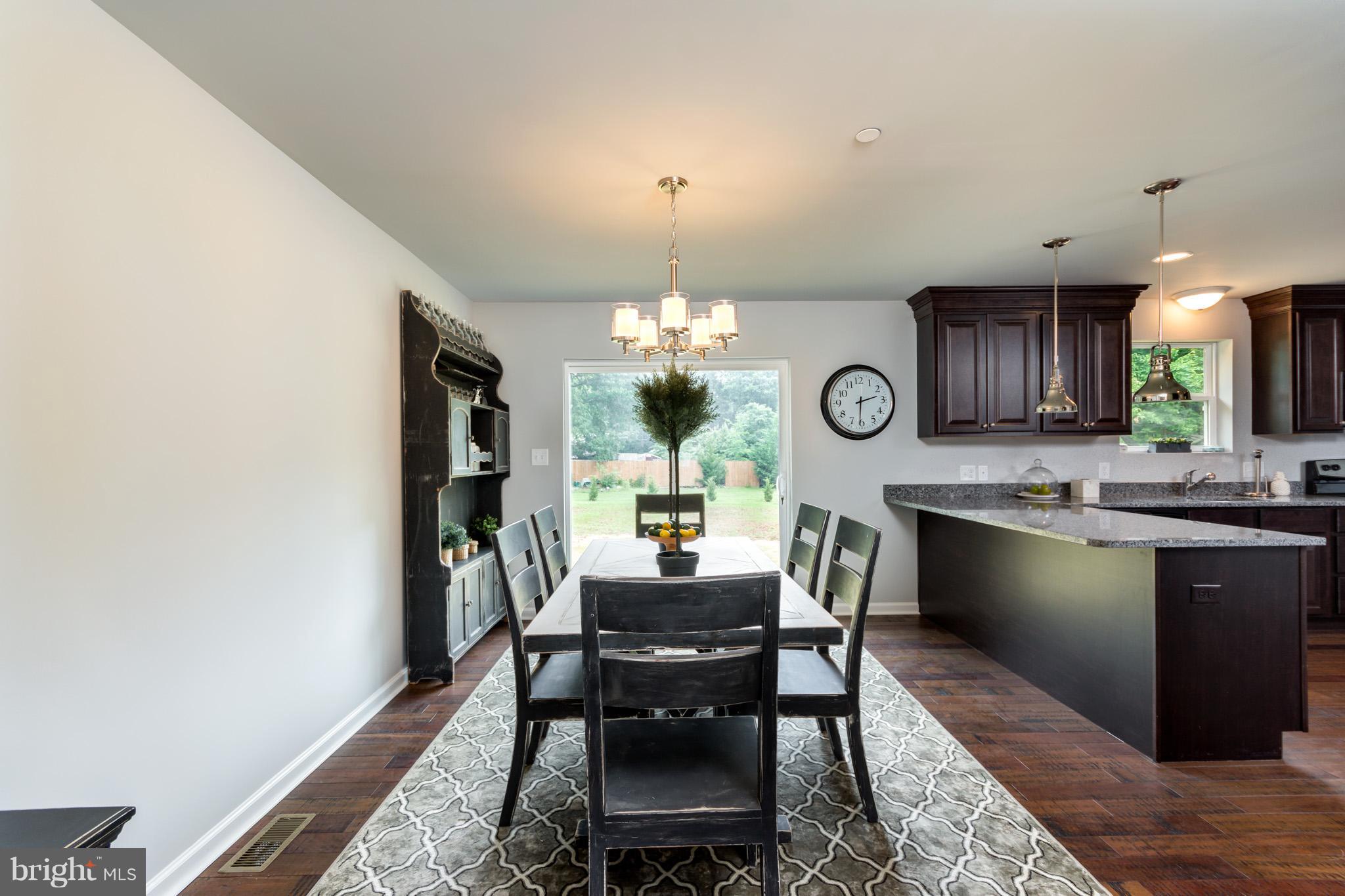 8035 Clark Station Road Severn, MD 21144 - Photo 6 of 24 a dining room with wooden floor a chandelier a wooden table and chairs