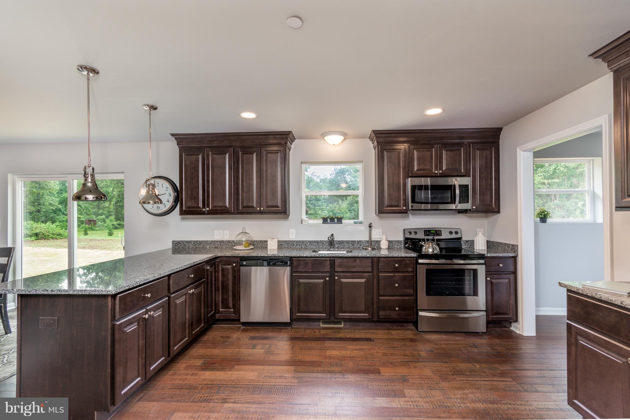 8035 Clark Station Road Severn, MD 21144 - Photo 8 of 24 a kitchen with stainless steel appliances granite countertop wooden cabinets a sink a stove a microwave and wooden floors