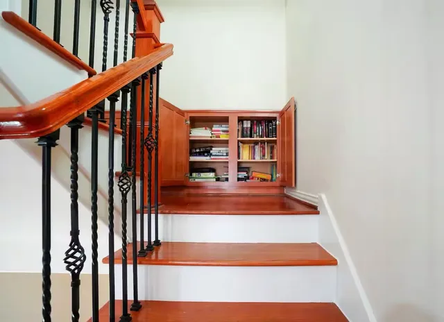 a view of staircase with wooden floor and book shelf