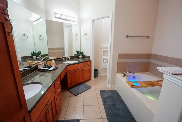 a bathroom with a tub sink and mirror