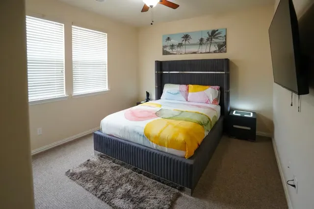 a bed sitting in a bedroom and flat screen tv
