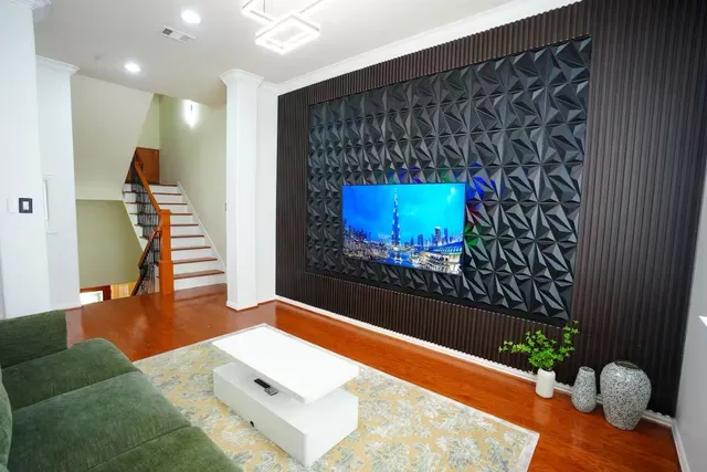 a living room with furniture and a wooden floor