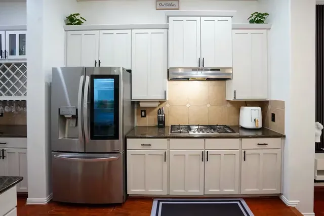 a kitchen with stainless steel appliances granite countertop a refrigerator and a stove