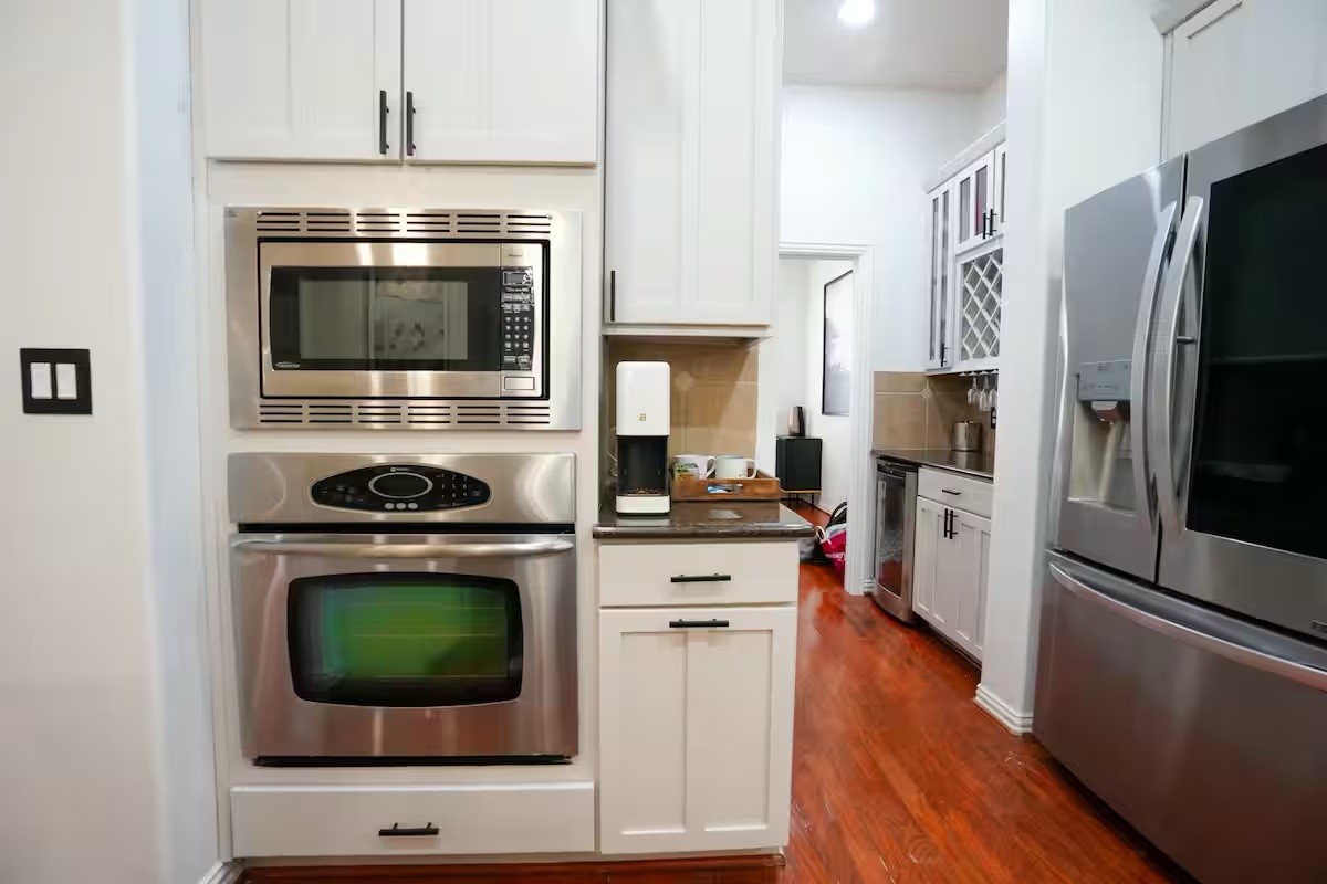 5625 Dolores Street, Unit B Houston, TX 77057 - Photo 10 of 40 a kitchen with cabinets stainless steel appliances and wooden floor