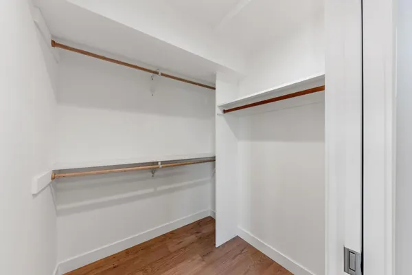 a view of walk in closet with empty racks