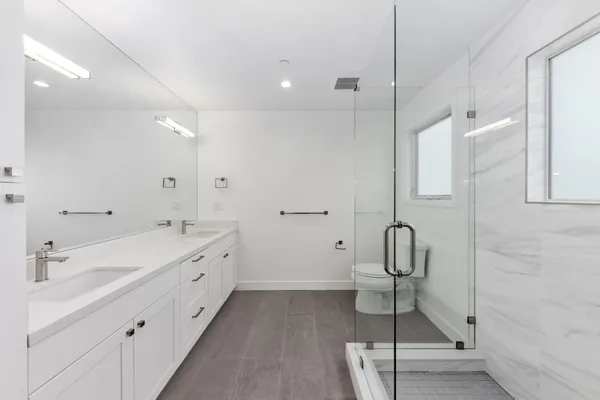 a bathroom with a double vanity sink a toilet and a mirror