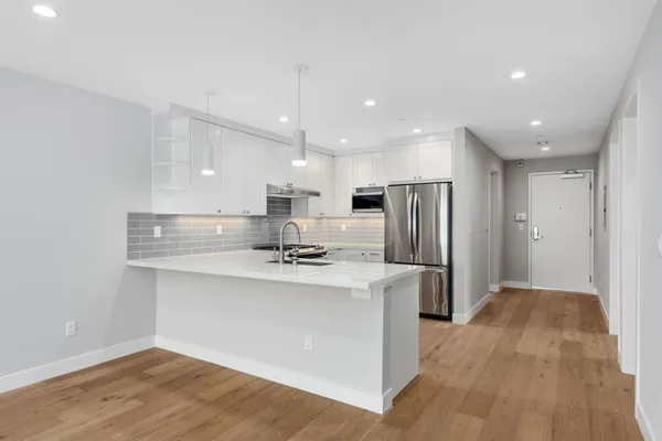 a kitchen with stainless steel appliances granite countertop a sink a refrigerator and a stove top oven