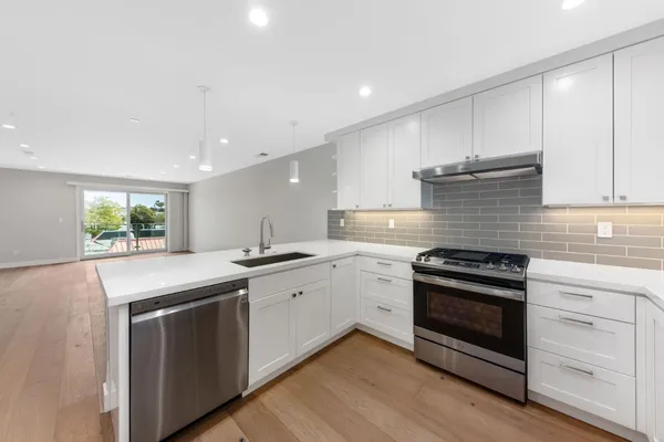 a kitchen with stainless steel appliances granite countertop a sink and stove top oven