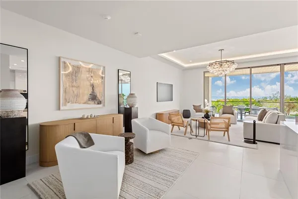 a living room with furniture and floor to ceiling windows