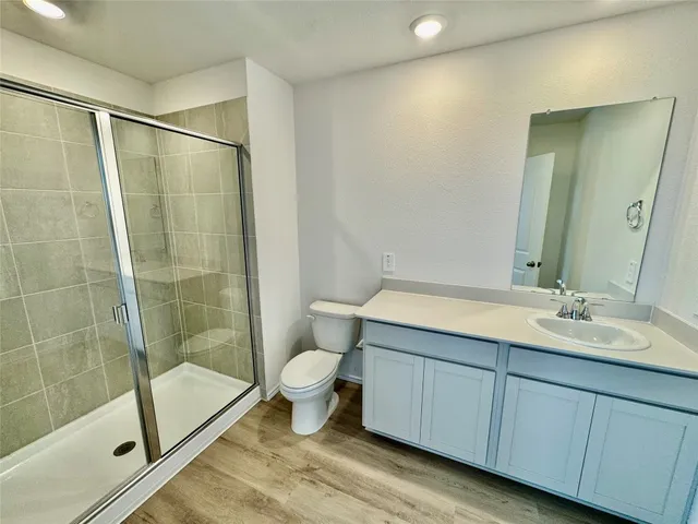 a bathroom with a granite countertop sink toilet a mirror and shower