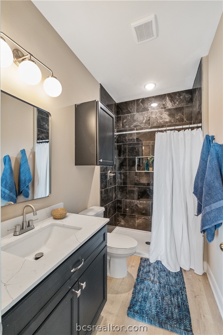 800 North Parker Avenue Bryan, TX 77803 - Photo 11 of 13 a bathroom with a sink a toilet a mirror and shower