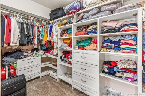 a view of walk in closet with clothes and shoes