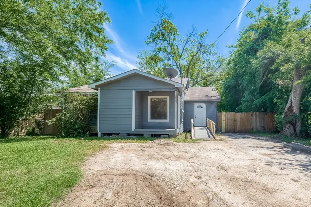 a view of a house with a yard and large tree