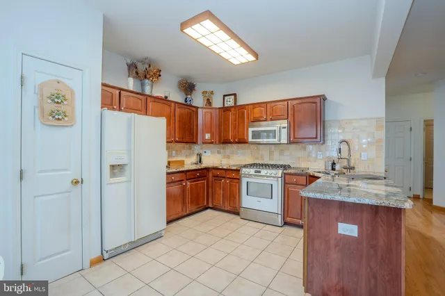 a kitchen with stainless steel appliances granite countertop a refrigerator sink and stove