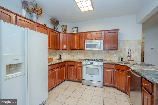 a kitchen with stainless steel appliances granite countertop a sink and cabinets