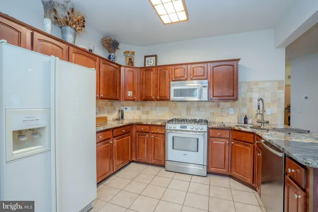 a kitchen with stainless steel appliances granite countertop a sink and cabinets