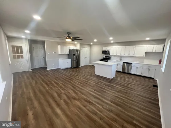 a large kitchen with a large window a sink and stainless steel appliances