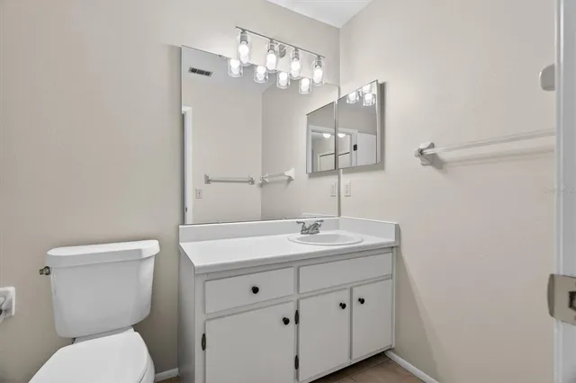 a bathroom with a toilet a sink and mirror
