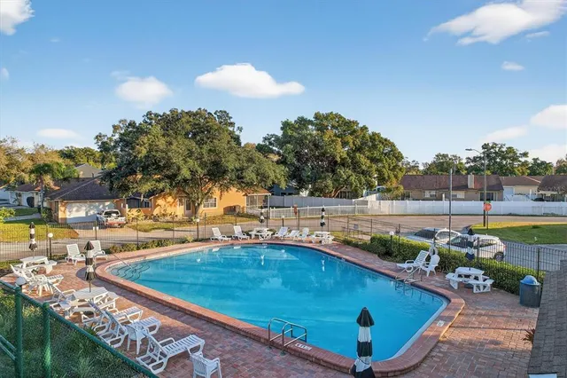 a view of a swimming pool with a patio and a yard