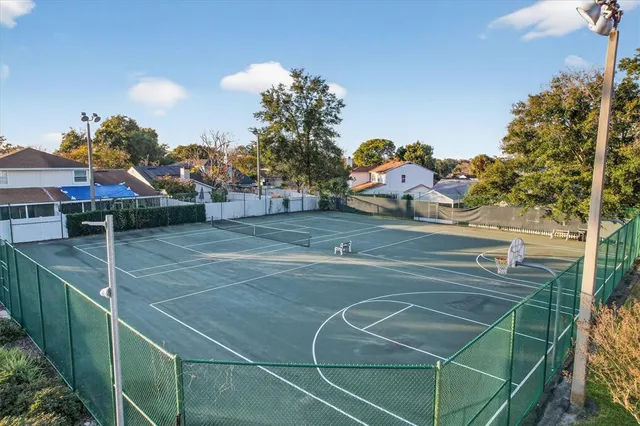 a view of a tennis ground with large trees