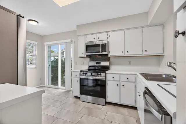 a kitchen with cabinets stainless steel appliances and a counter space