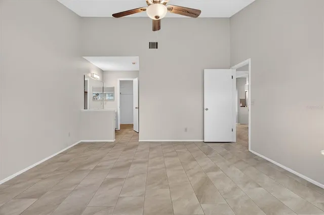 a view of an empty room with a chandelier fan