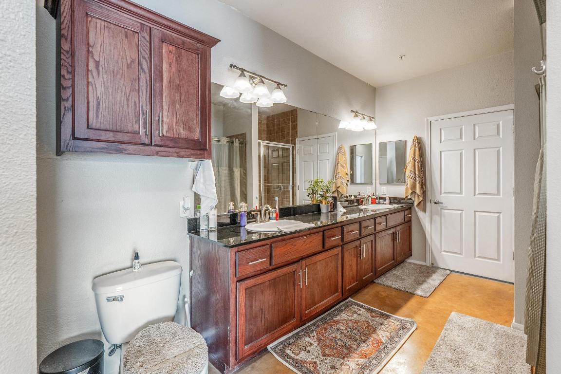 910 West 25th Street, Unit 406 Austin, TX 78705 - Photo 10 of 18 a bathroom with a granite countertop sink and a mirror