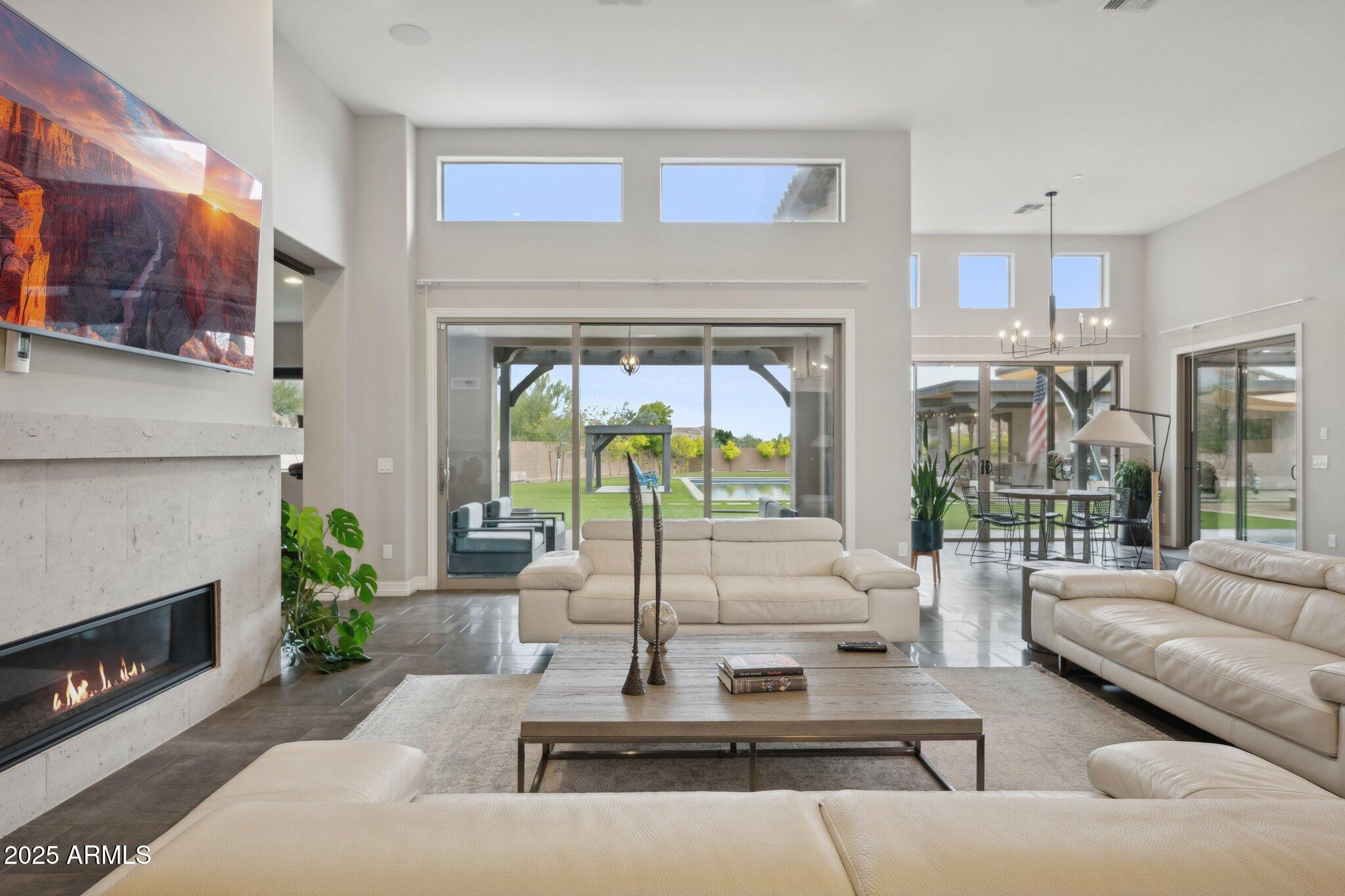 5237 East Montgomery Road Cave Creek, AZ 85331 - Photo 13 of 79 a living room with furniture a floor to ceiling window and a fireplace