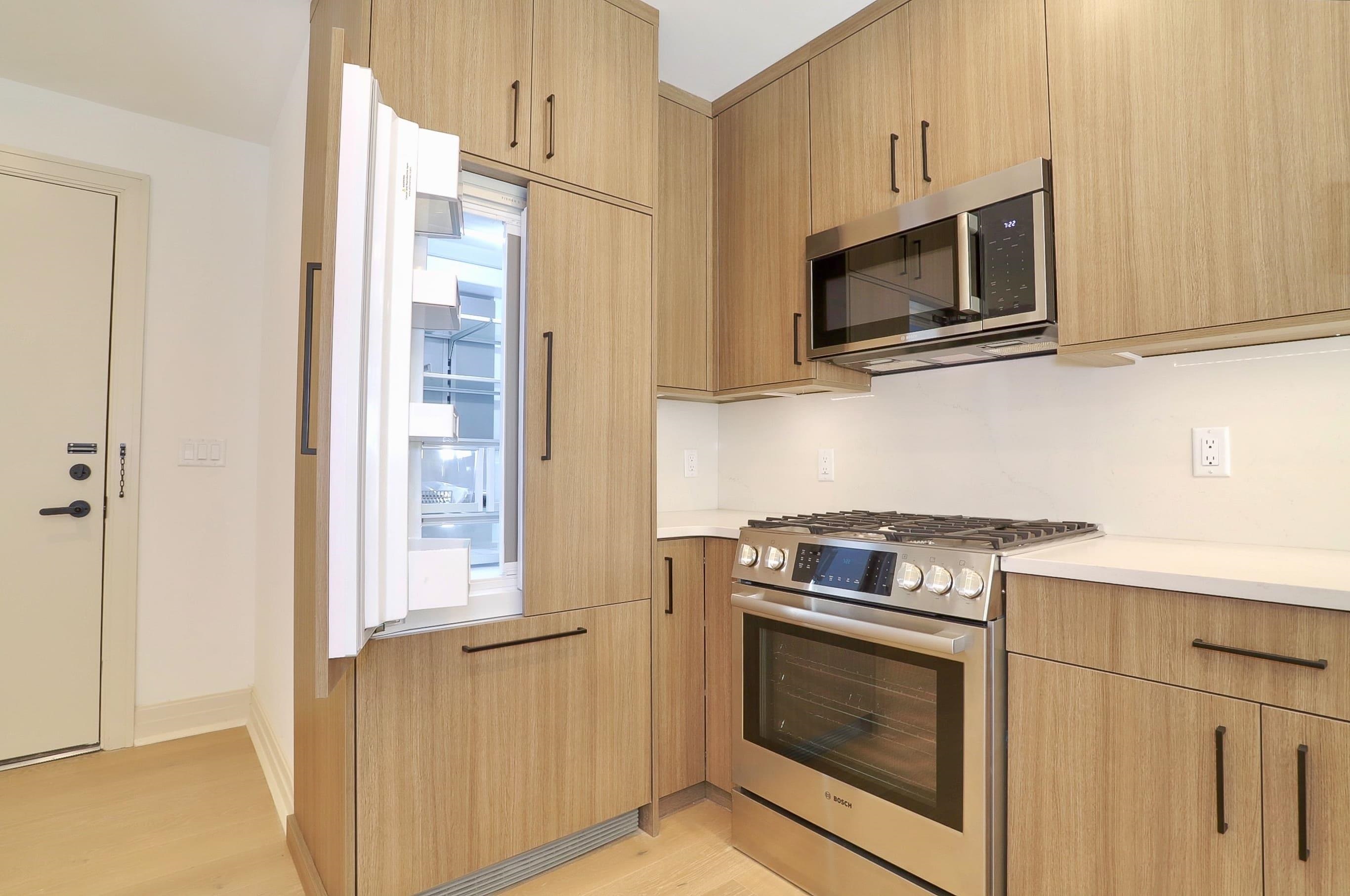 921 Madison Street, Unit 401 Hoboken, NJ 07030 - Photo 4 of 32 a kitchen with stainless steel appliances granite countertop white cabinets a microwave oven and a refrigerator
