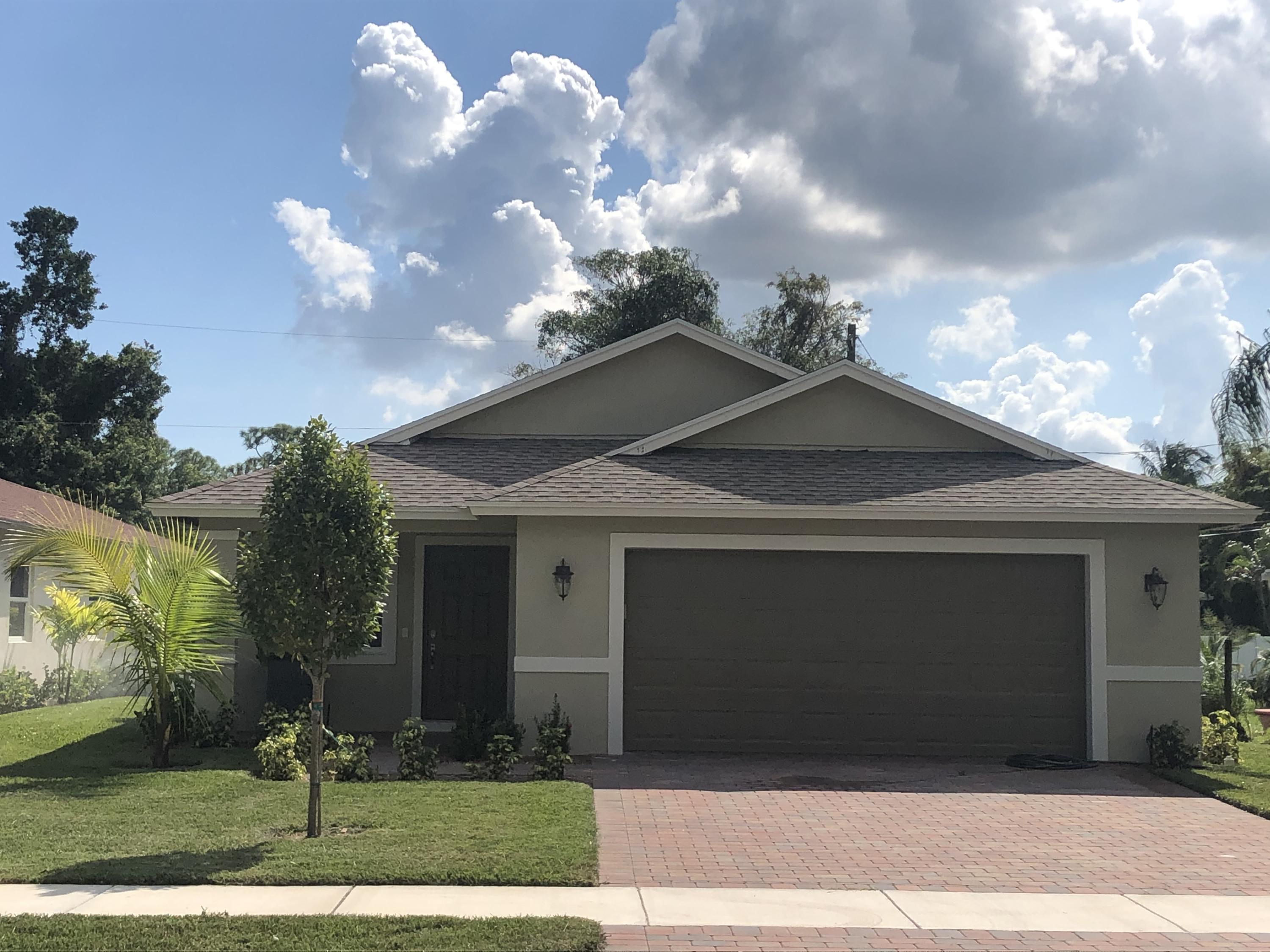 4936 Jefferson Road Delray Beach, FL 33445 - Photo 1 of 16 a front view of a house with garden