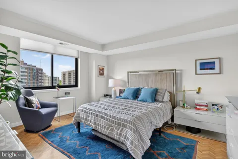a bedroom with a bed and large windows