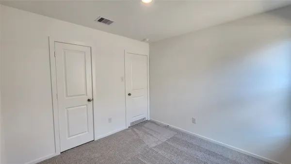 a view of an empty room with a window and closet area