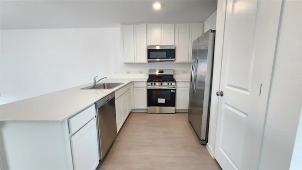 a kitchen with a stove a sink and a microwave