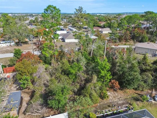 an aerial view of residential house with outdoor space and trees all around
