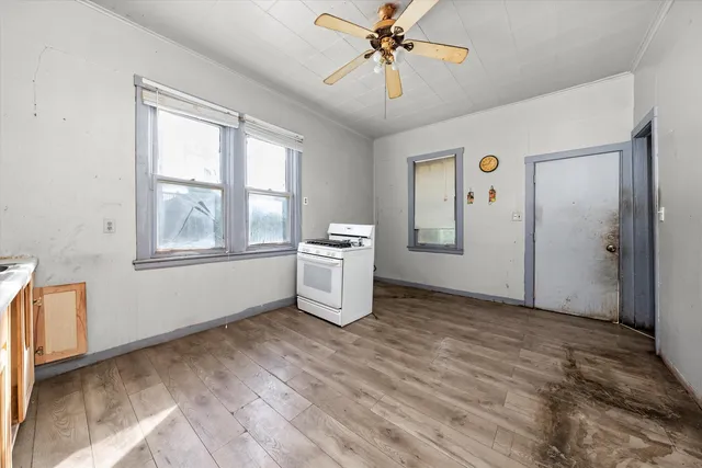 a view of an empty room with window and wooden floor