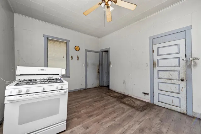 a kitchen with a stove and a wooden floor