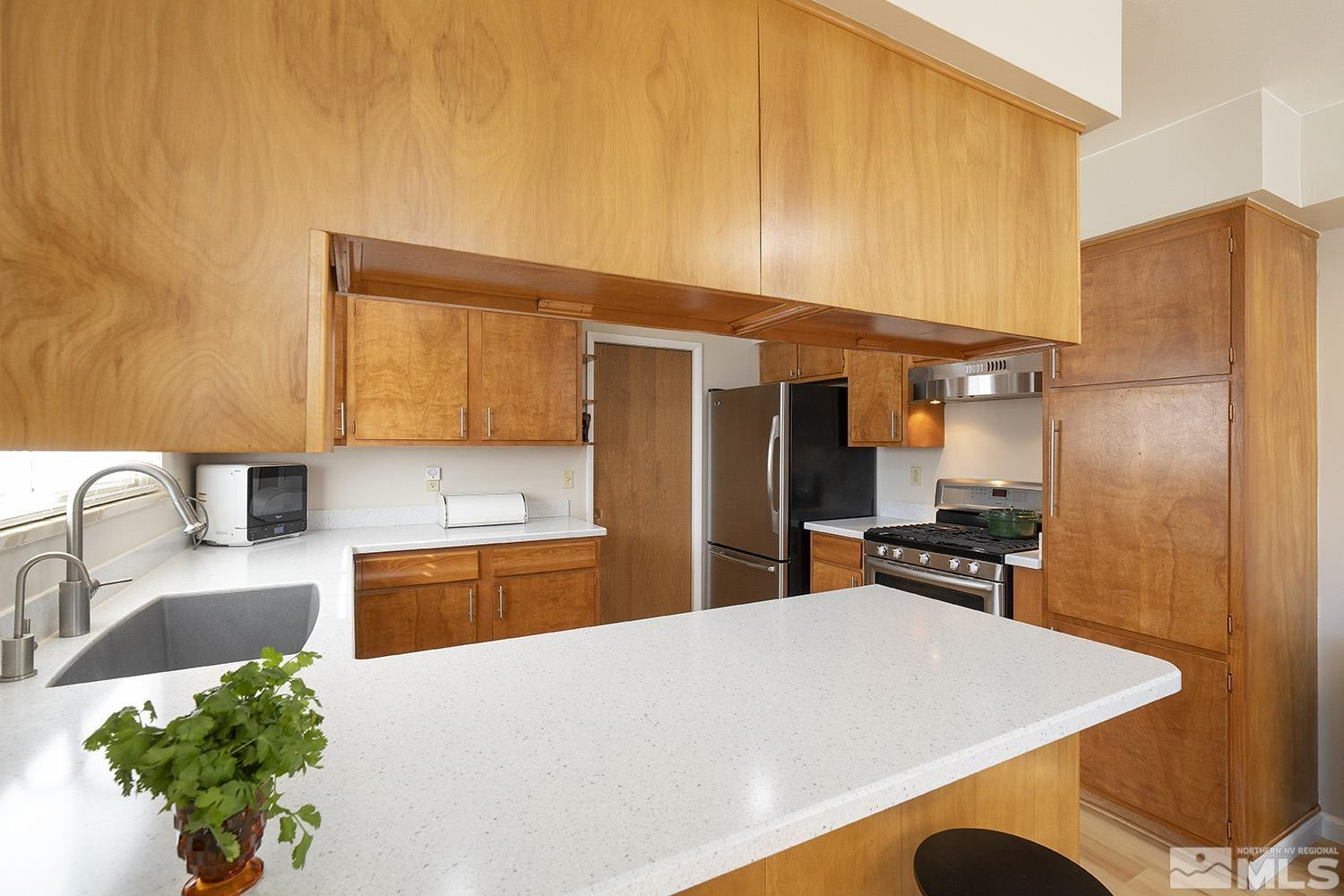 3310 Cashill Boulevard Reno, NV 89509 - Photo 8 of 40 a kitchen with stainless steel appliances granite countertop a sink refrigerator and cabinets
