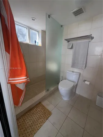 a bathroom with a toilet and a shower