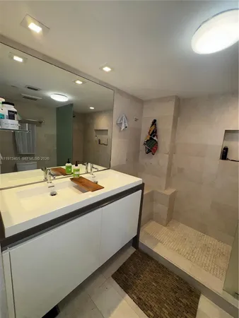 a bathroom with a sink a large mirror and shower