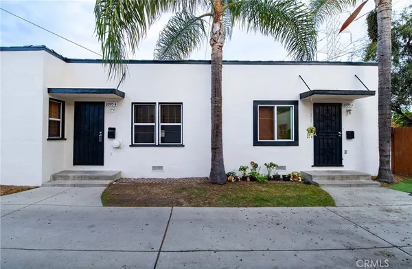 a view of a house with a yard and palm trees